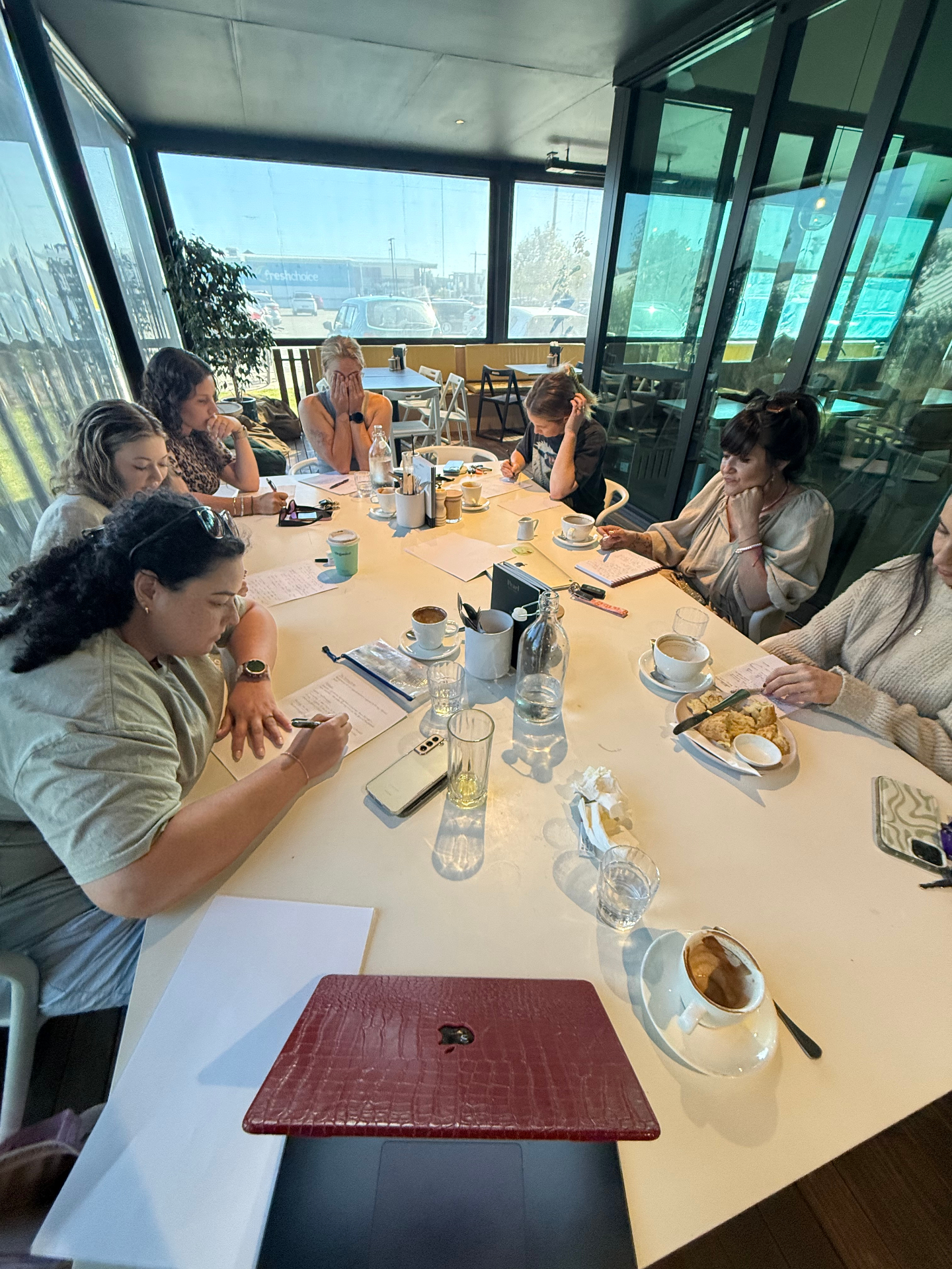 Women in business gathered around a table at a She Is Unleashed weekly group
