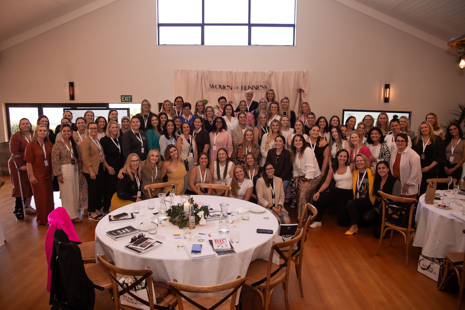 Women in business gathered around a café table, laughing and connecting